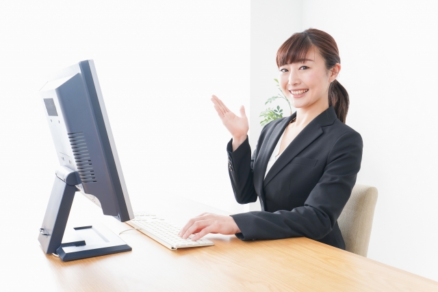 PCの前で手を上げる女性